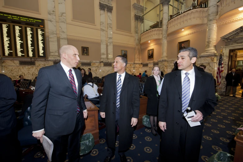 three men dressed in business attire in a el