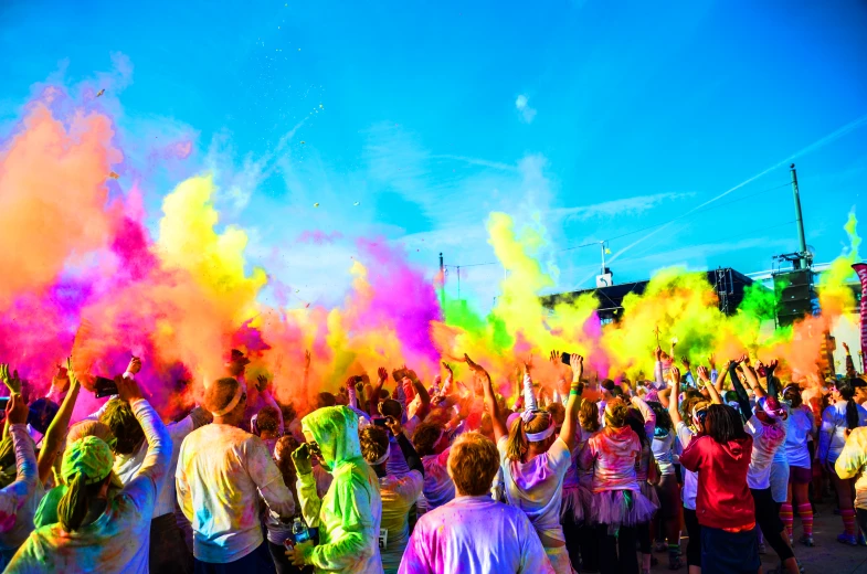 the crowd is throwing colored powder into the air