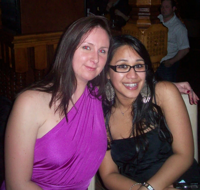 two women smiling for the camera in a restaurant