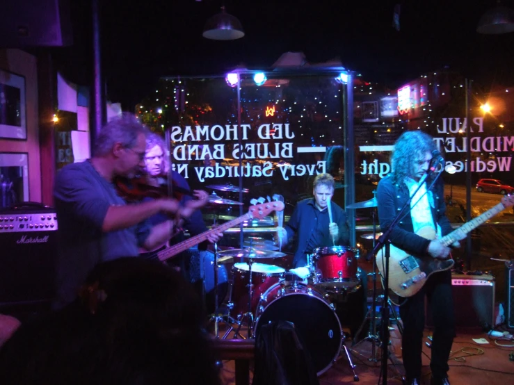 people playing music with a band under a tent