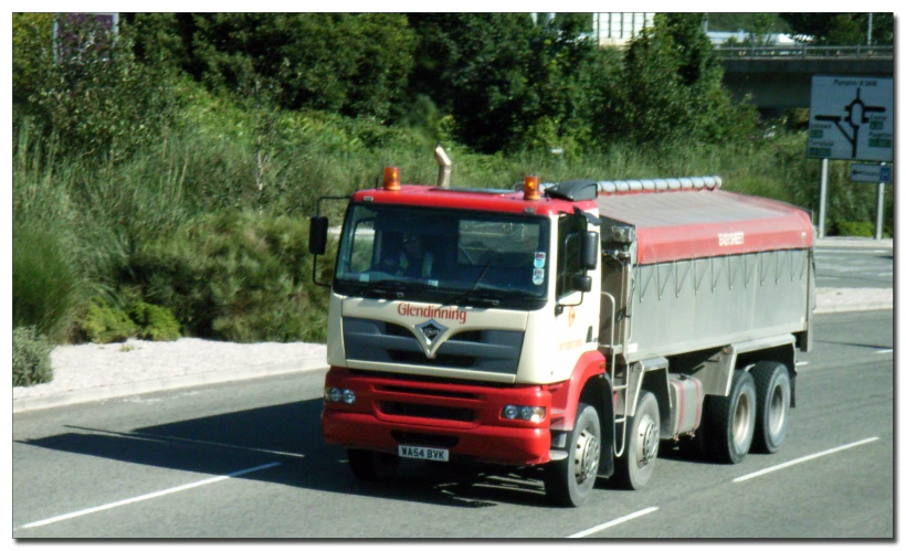 a red and white truck is driving down the street