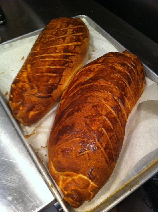 two croissants sitting on top of a baking sheet