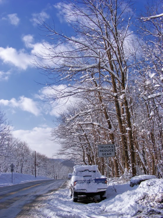 a truck parked on the side of the road covered in snow