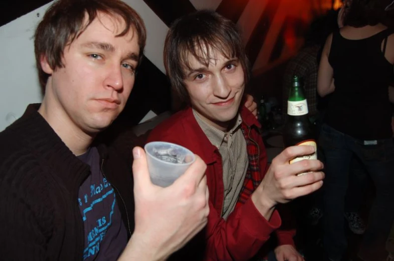 two guys in black and red holding a beverage