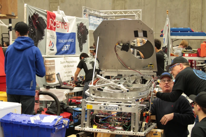 a group of people talking and having conversation at a robotics competition