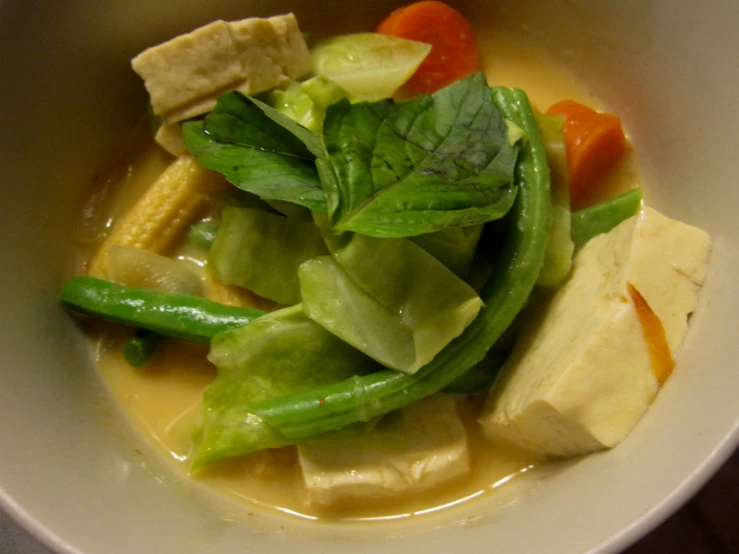 a bowl of vegetable soup with a garnish of green peppers