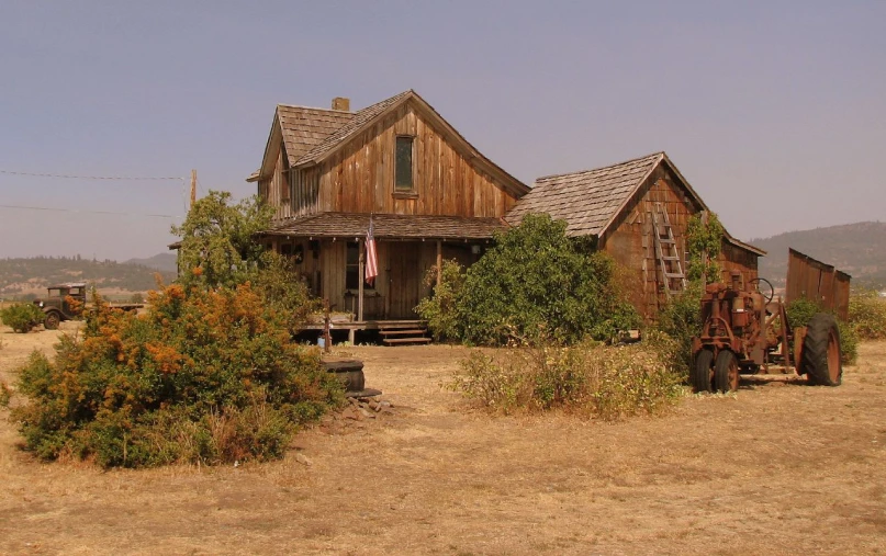 old wooden farm house with american flag in the window