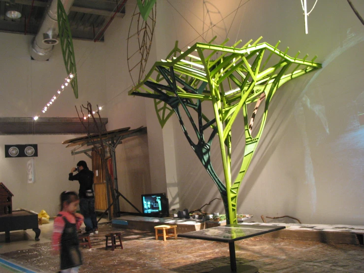 a tall green sculpture in the middle of a room