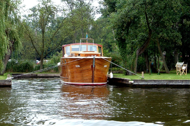 a boat sitting on top of a river next to a dock
