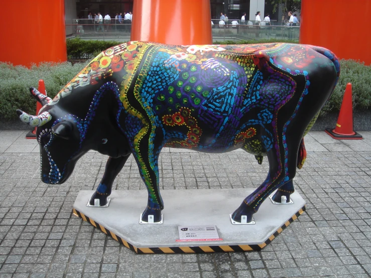a brightly painted cow in an outdoor courtyard