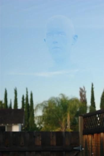 a reflection of a man over a fence