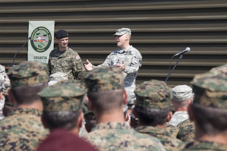 a group of soldiers standing and talking to a man