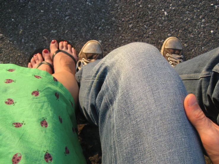 two people are sitting close together with one holding the other's leg