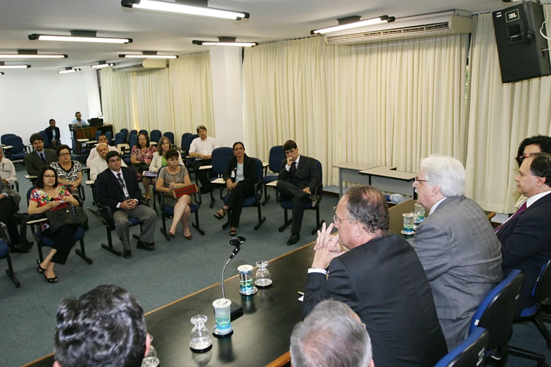 a meeting room filled with people sitting and standing