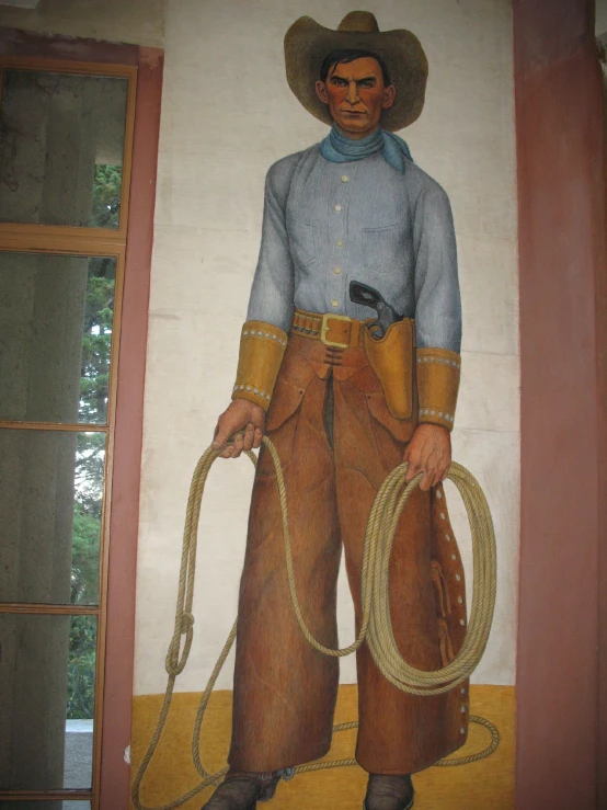 the mural depicts the cowboy in blue and brown clothing with a pair of large boots