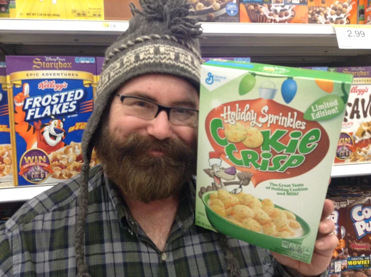 man holding up cereal in front of store shelves