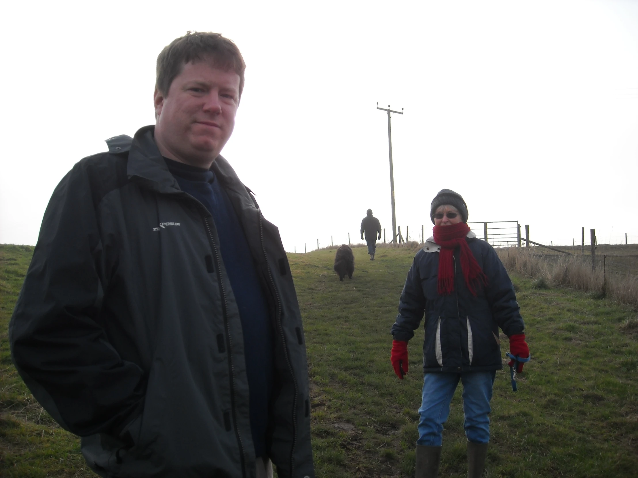 a man and woman walking through an open field