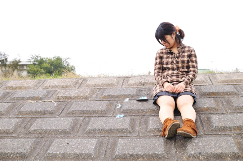 the girl sits on top of an old roof