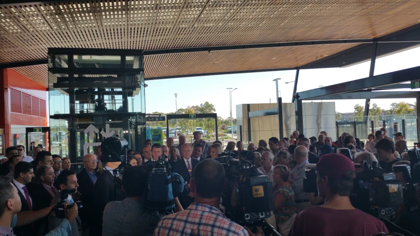 crowd of people standing in front of building under awning