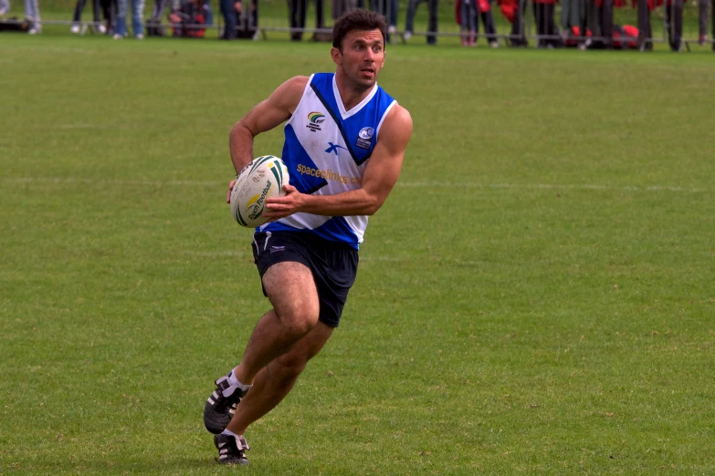 a young man running with a football on a field