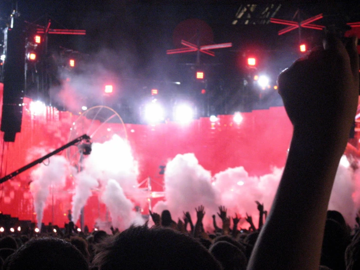 a crowd of people waving and singing on stage