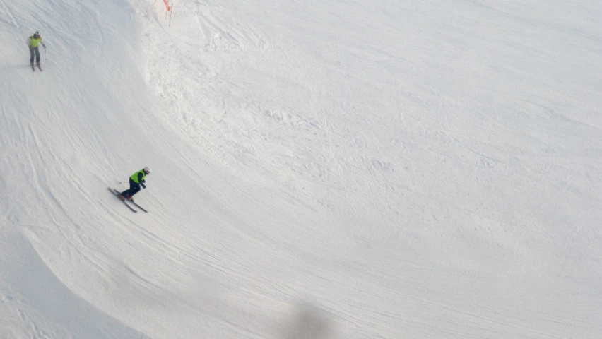 two people skiing down a large slope of snow