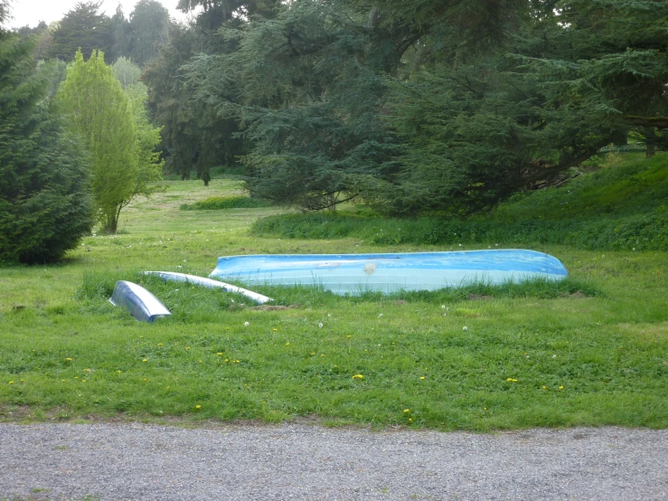 some little blue boat that is on a lawn