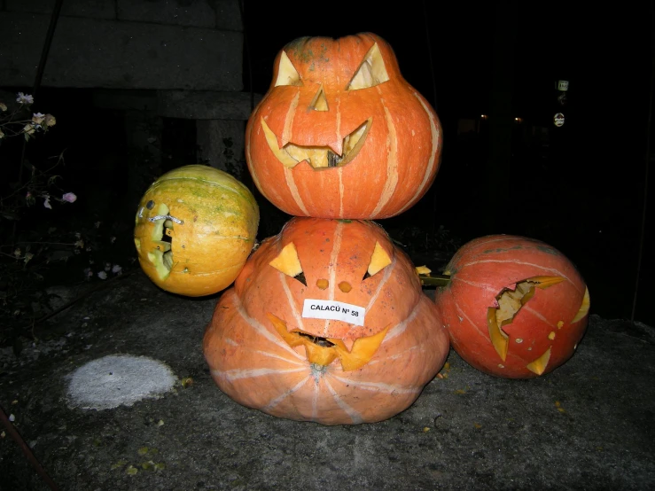 a pumpkin statue with a carved face and four other pumpkins