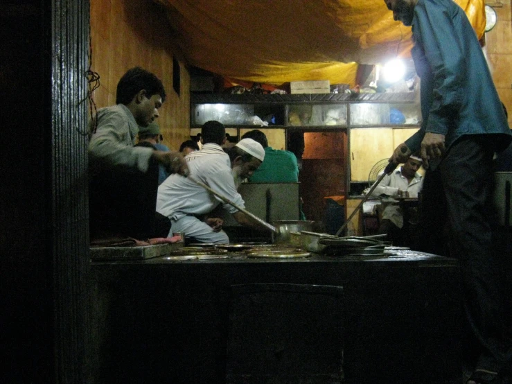 a group of people sitting around a kitchen on top of a stove