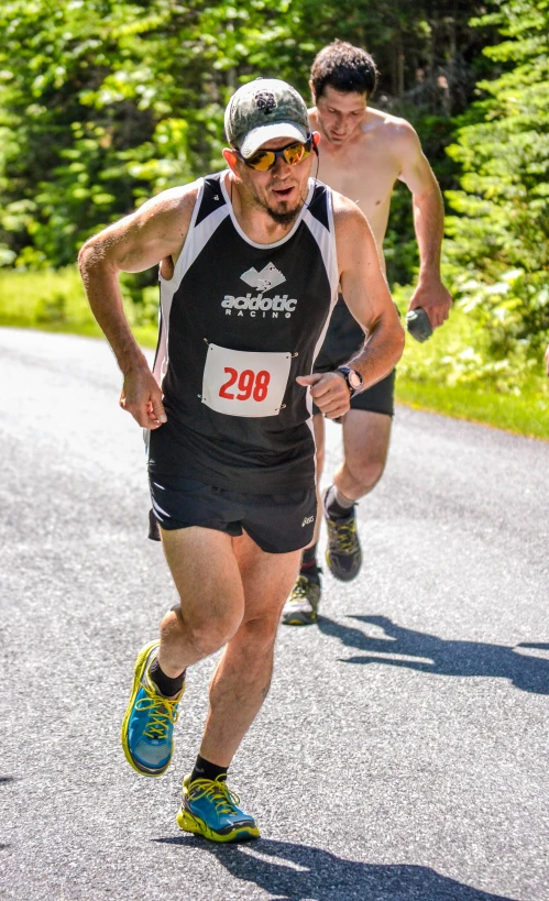 men run along a road near the forest