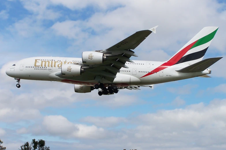 an emirates airplane flying through the air in the daytime