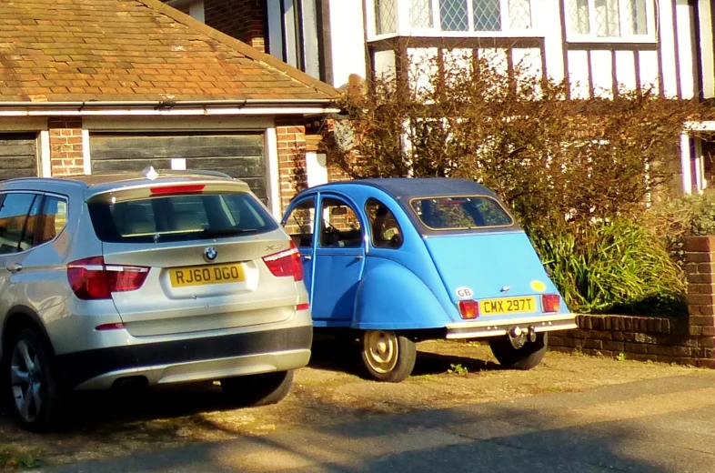 two cars are parked near one another on a driveway