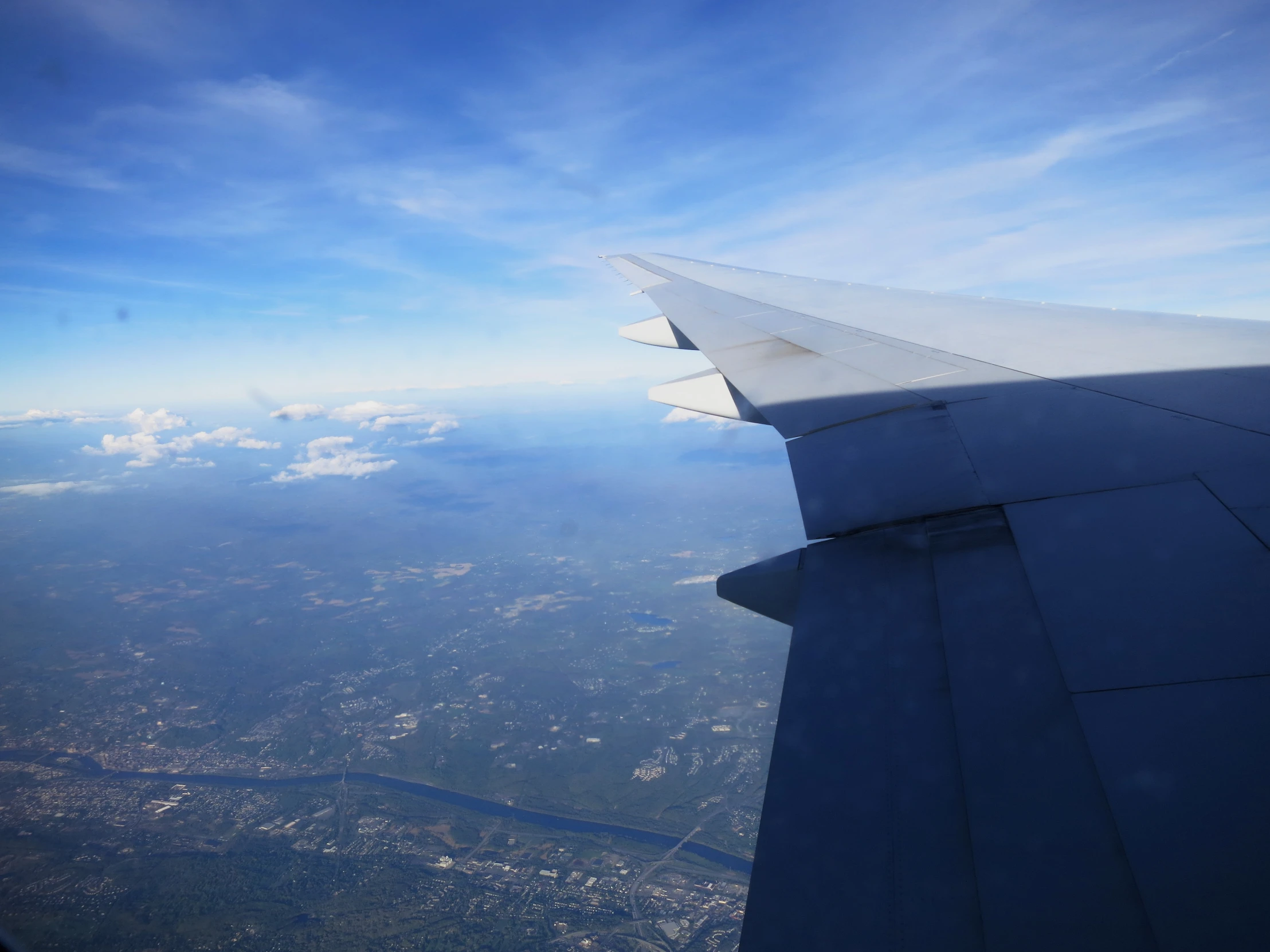 the wing of an airplane is above the clouds