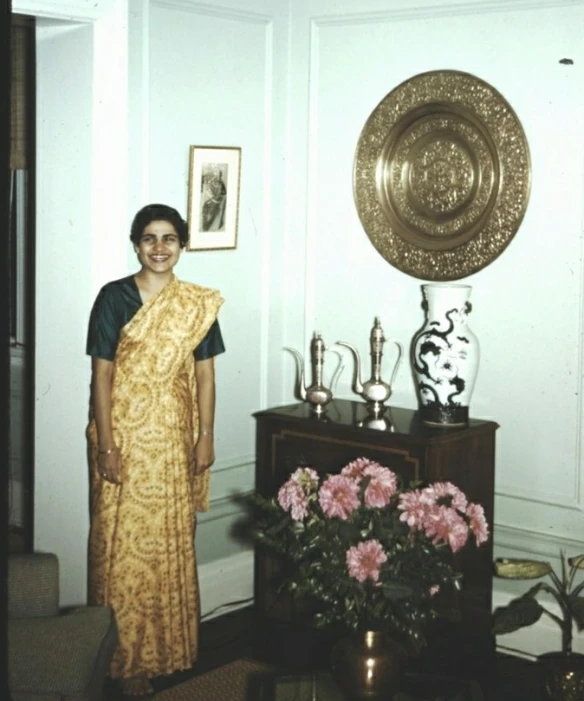 an old fashion woman in a yellow sari posing for the camera