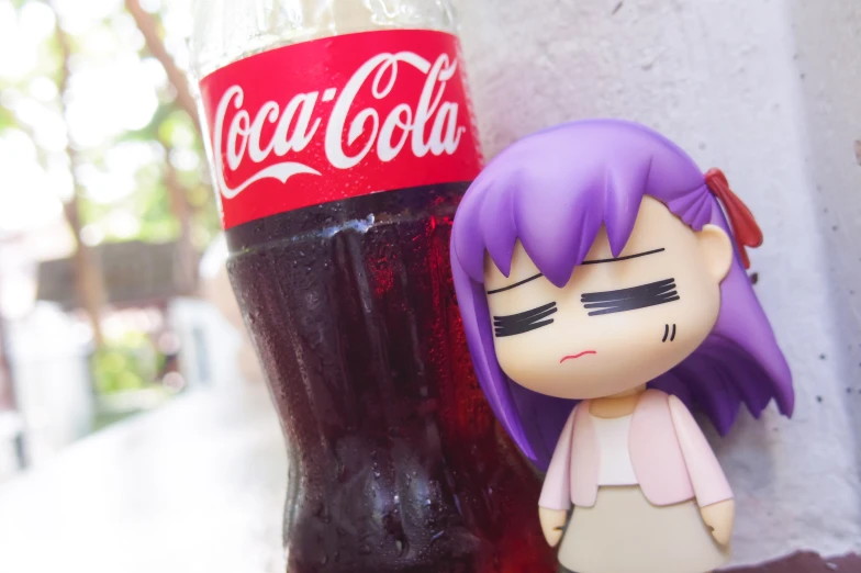 a cute doll next to an icy soda