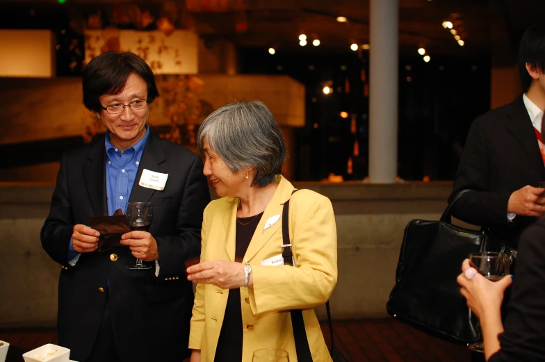 two asian people standing together at a business gathering