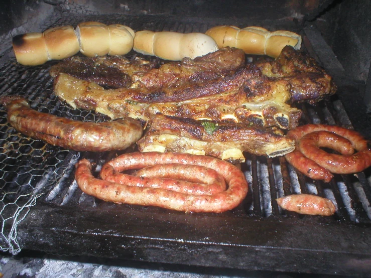 a bunch of sausages are being cooked on a grill