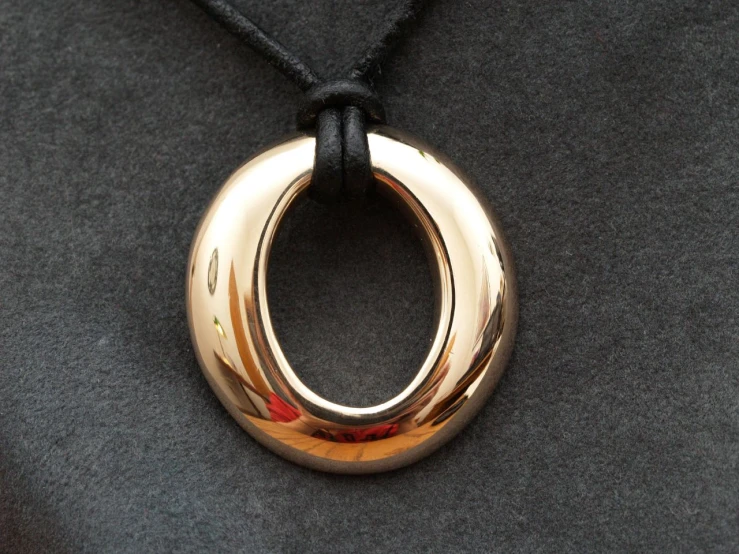 a round pendant hangs on a black string