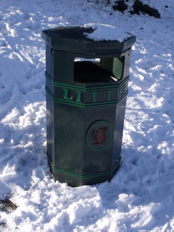 a trash can that is standing in some snow