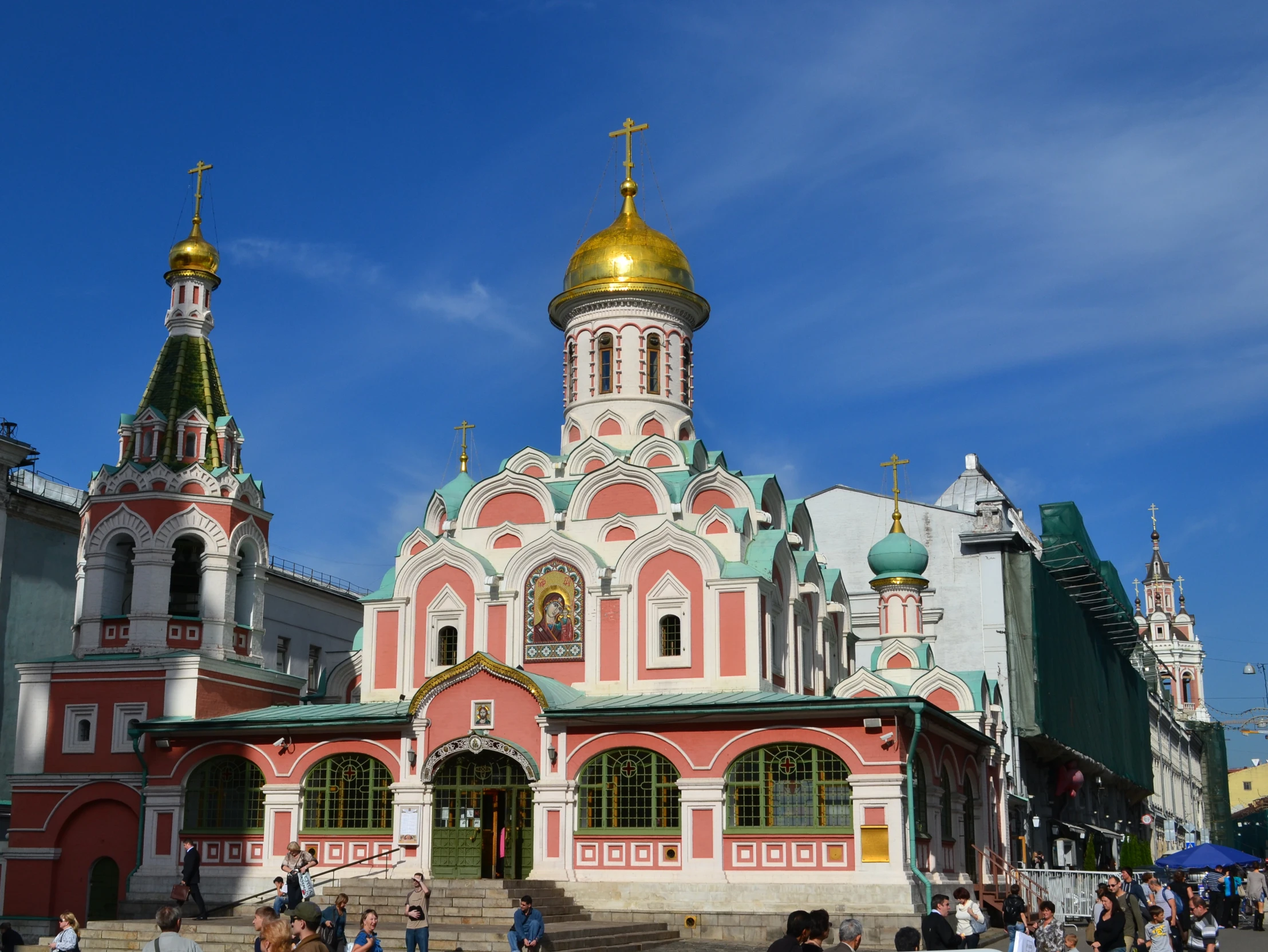 people are walking past colorful buildings and ornate architecture