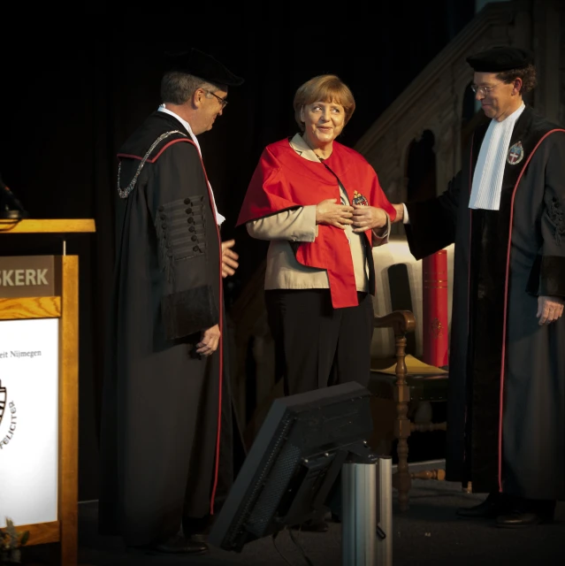 two men in red and black clothes talking to some women