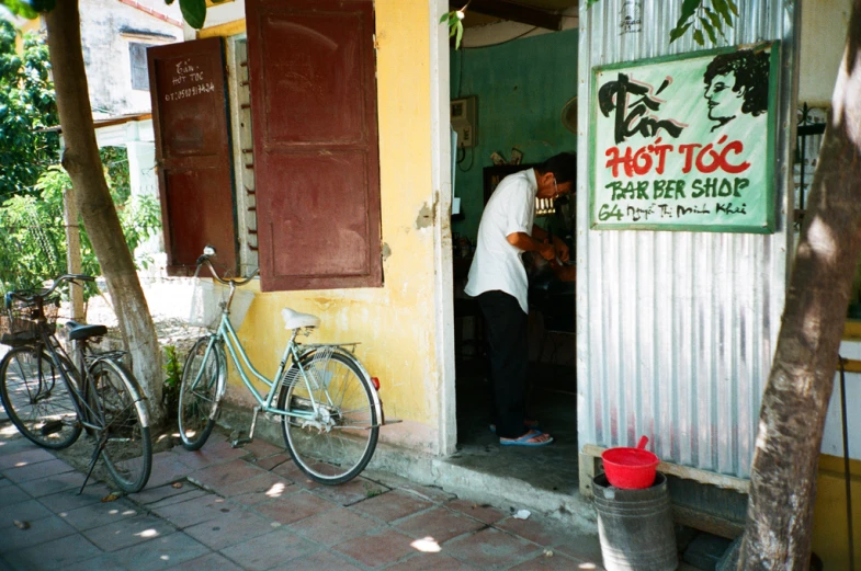 a man in a white shirt is opening the door to a store