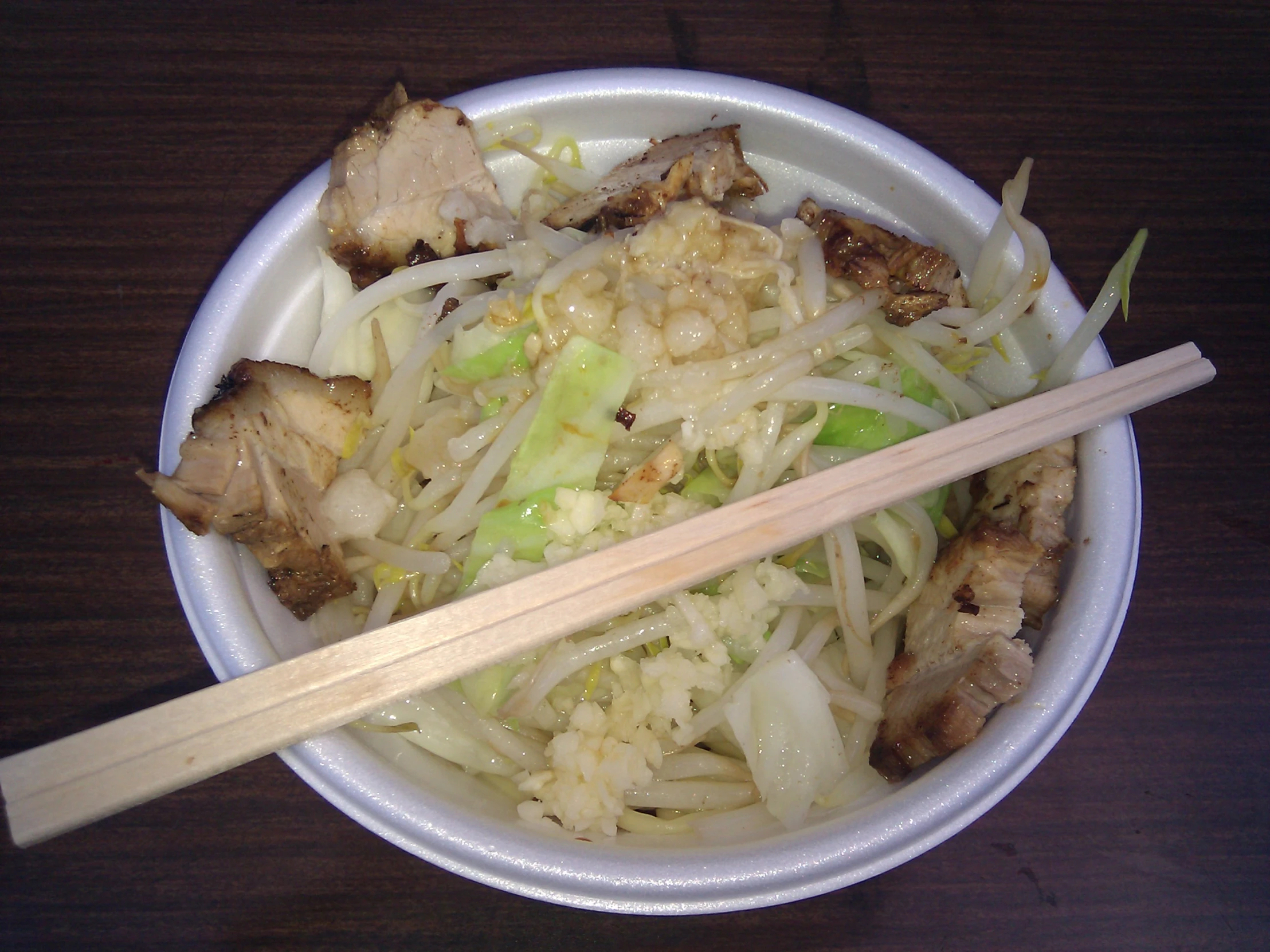 a bowl of food sitting on top of a wooden table