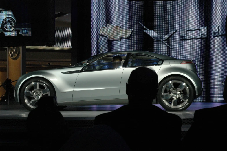 a man stands at the microphone talking to a car