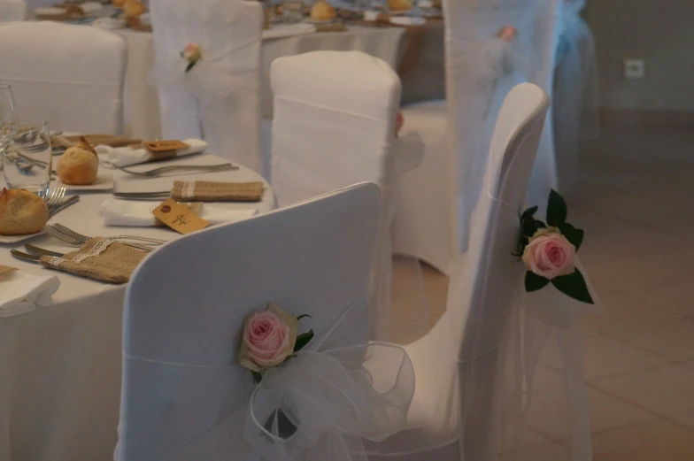 white wedding chairs decorated with flowers and decorations