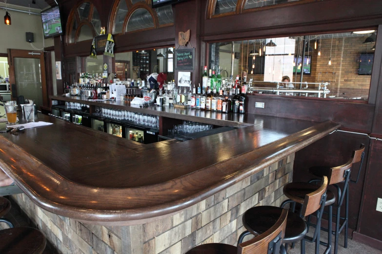 an old bar with many stools and a lot of bottles