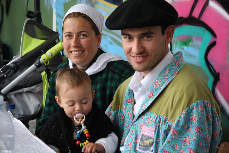 a woman and man holding a baby while wearing costumes