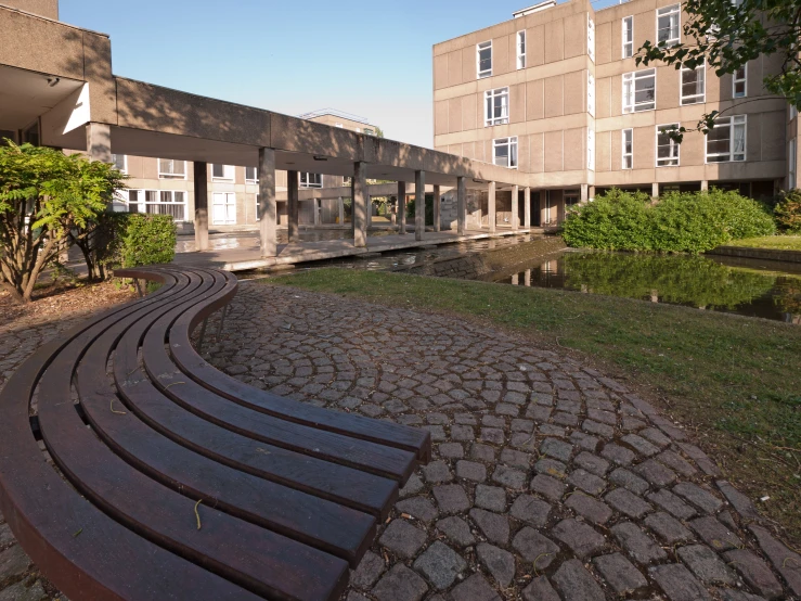 an empty bench sitting in a circle near a building