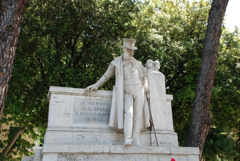 a white statue of a man with two men standing next to it