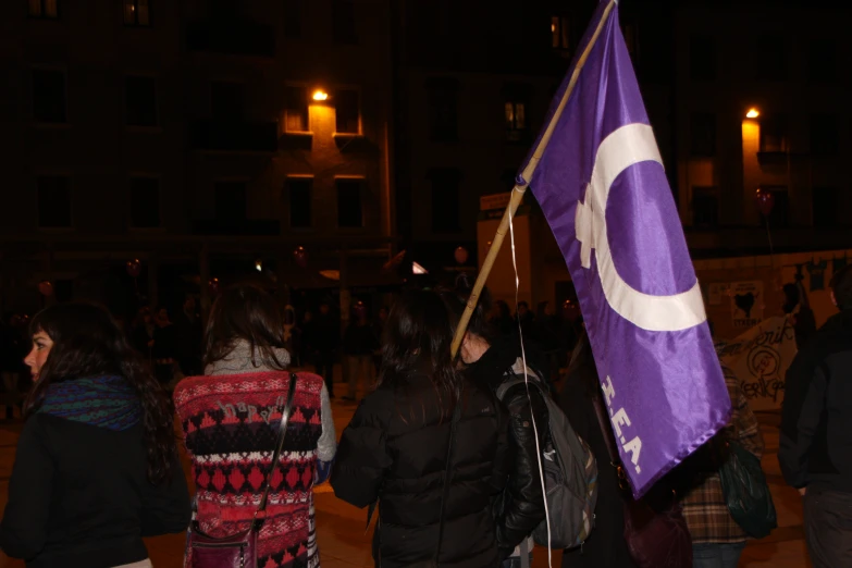 some people and a purple and white flag